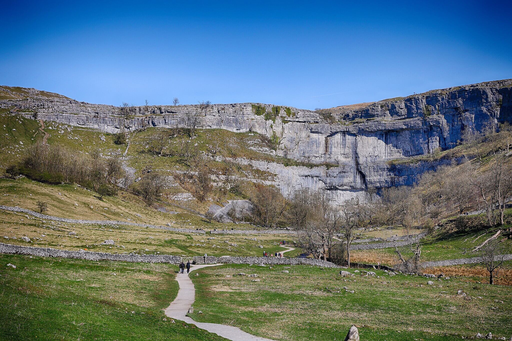 Shot of Malham Cove showing the dog friendly trail with people walking