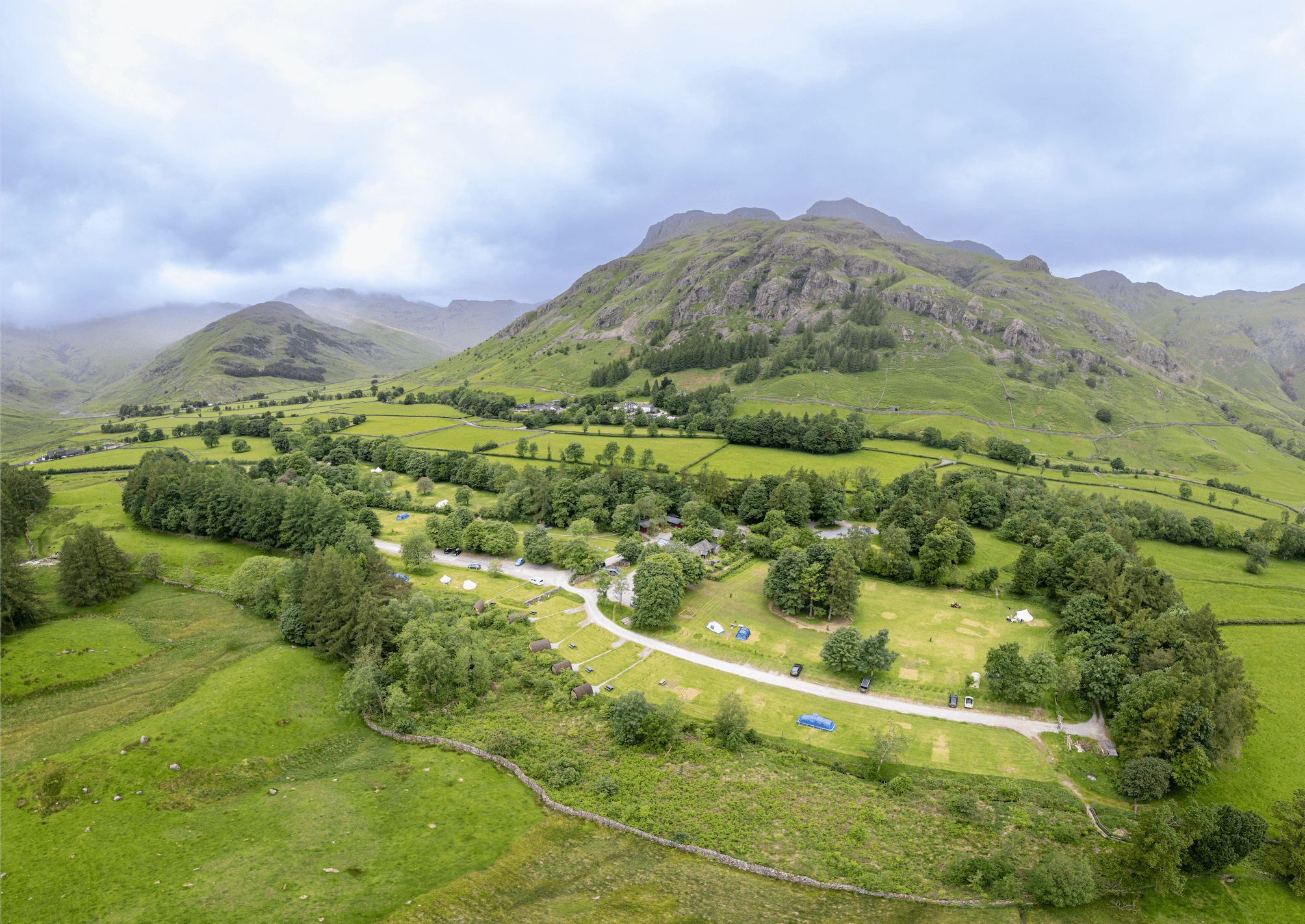 Aerial shot of Great Langdale Campsite with mountains in the background