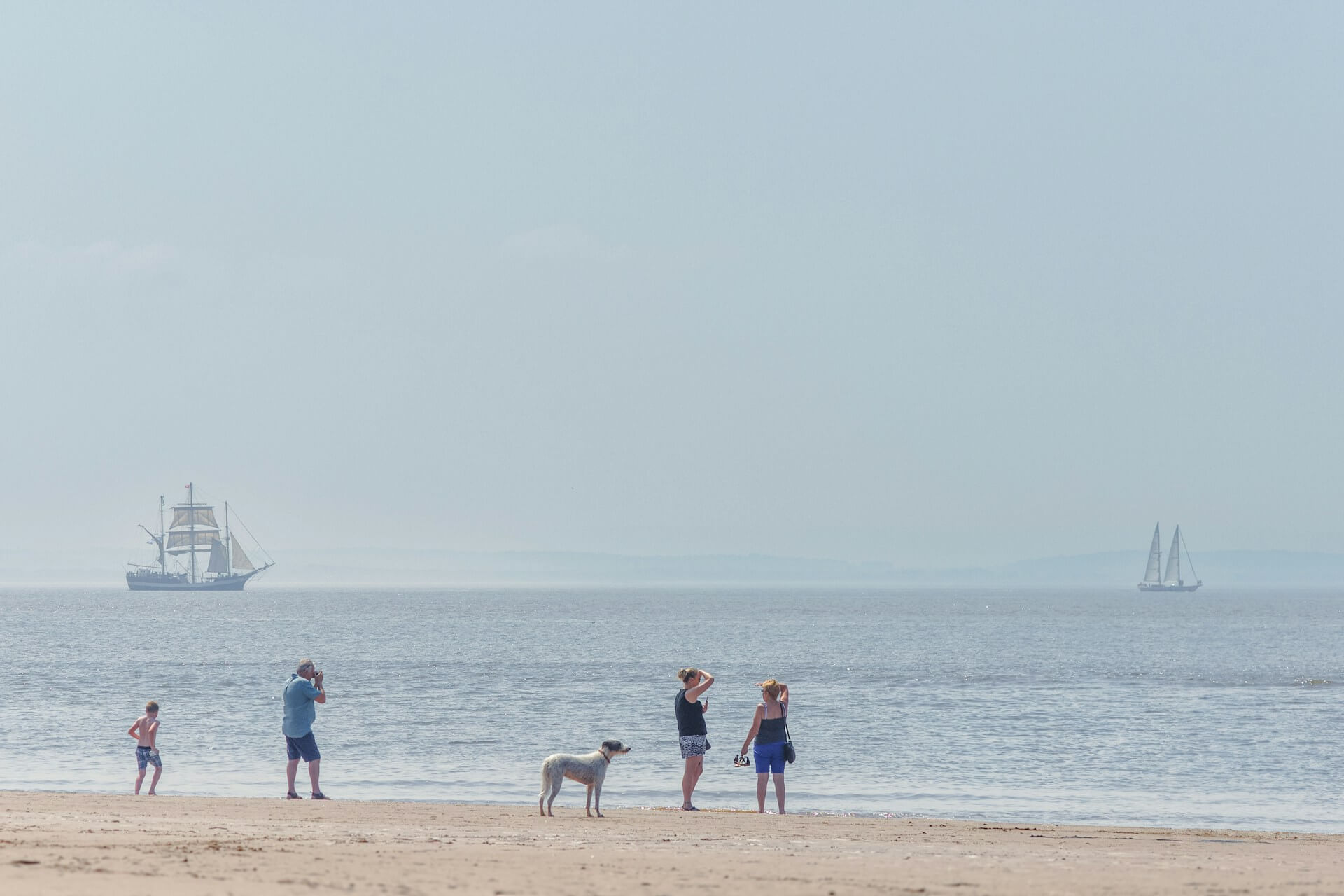 A family enjoy a dog friendly day out on Crosby Beach in Merseyside